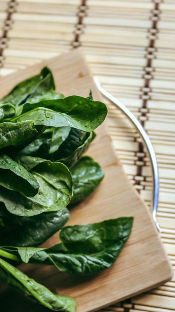 Mastering the First Impression: Your intriguing post title goes here Close-up of fresh spinach leaves on a wooden cutting board, perfect for healthy cooking themes.