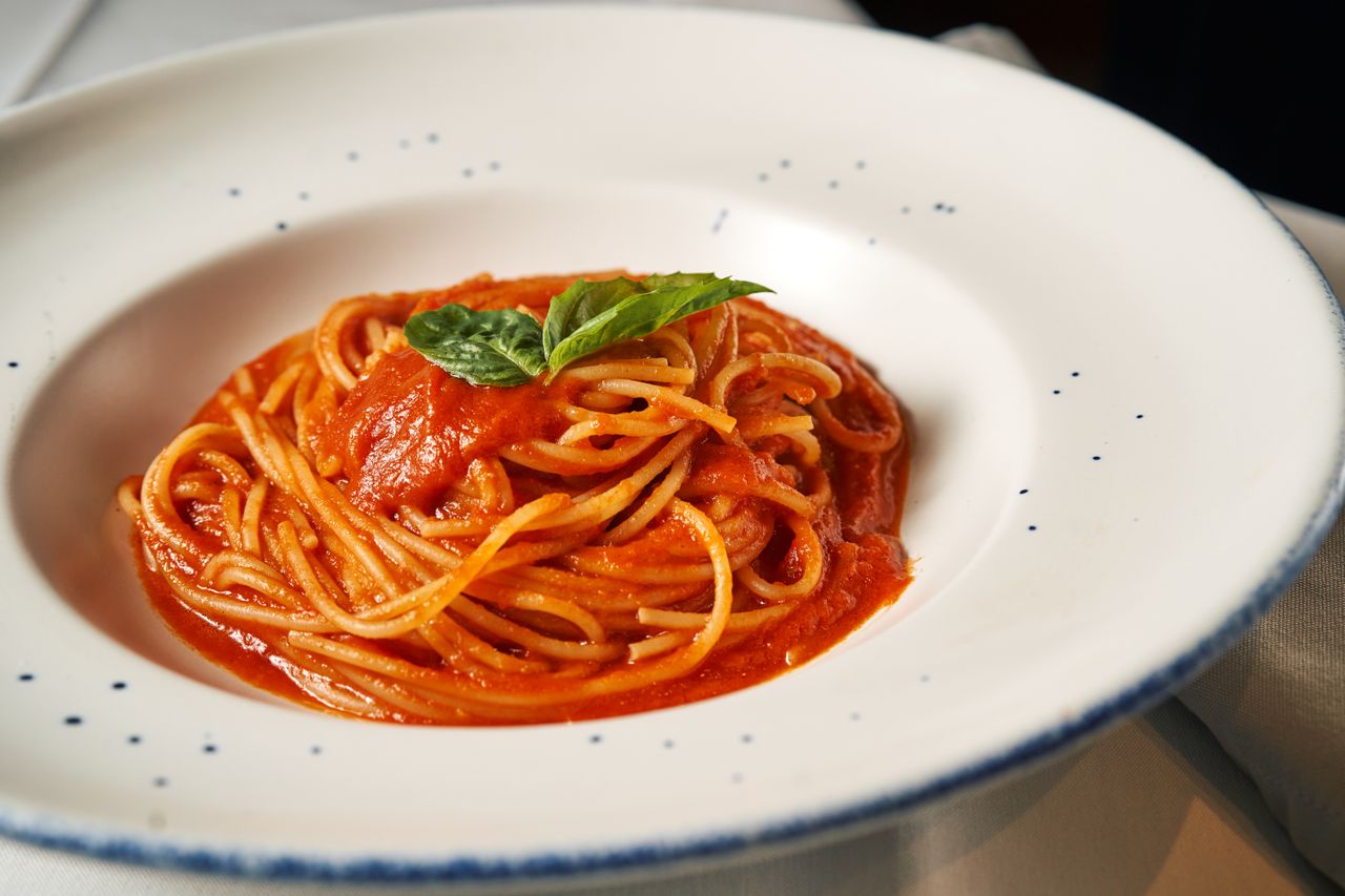 services-04 Classic Italian spaghetti in rich tomato sauce garnished with basil.