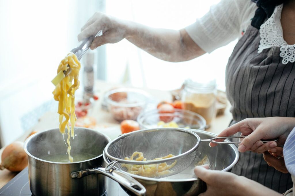 Crafting Captivating Headlines: Your awesome post title goes here Crop anonymous females in aprons cooking delicious pasta using tongs and strainer in kitchen